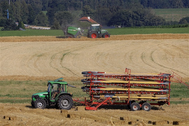 row of modern agricultural machinery tractors lined up farm yard ready for fieldwork